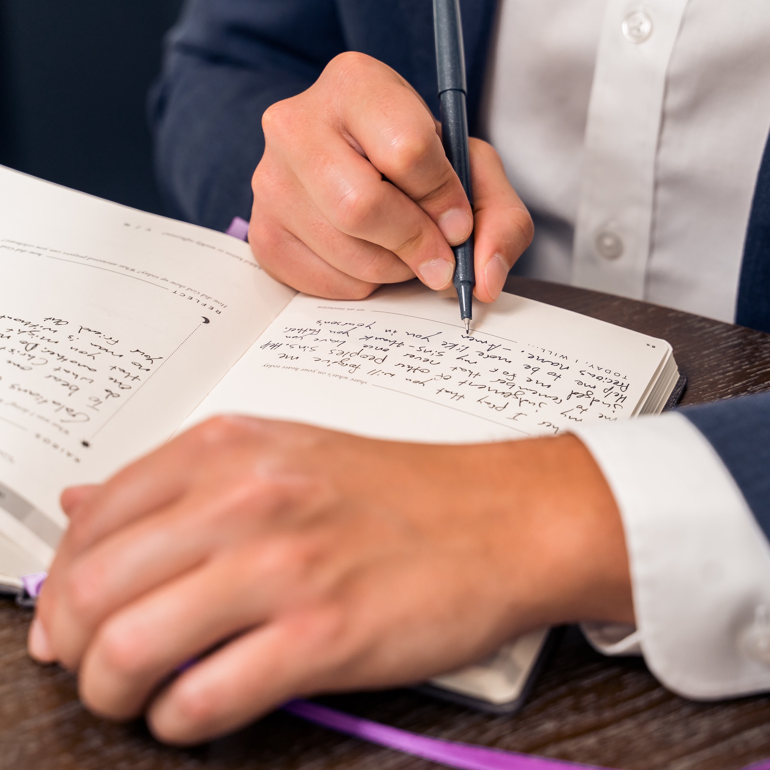 man writing in journal